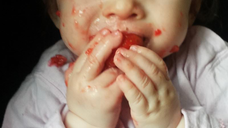 Baby isst Erdbeere