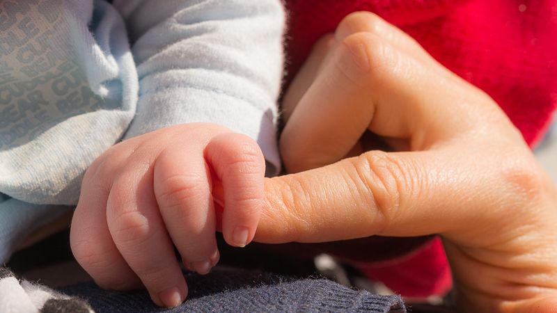 Baby umgreift Finger der Mama