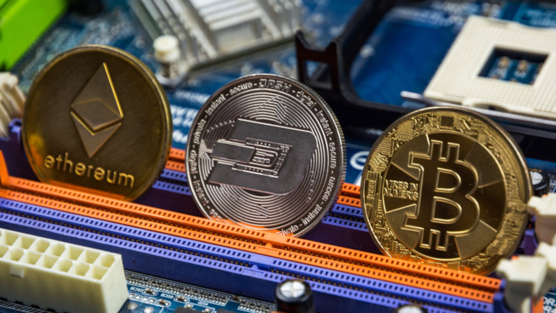 Ethereum, Dash und Bitcoin als Münzen auf Motherboard